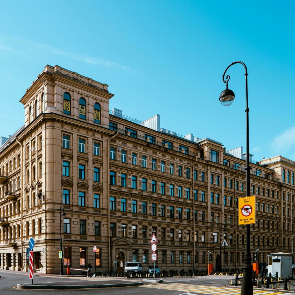 Elegant corner building in Saint Petersburg with classic architectural design and blue skies.